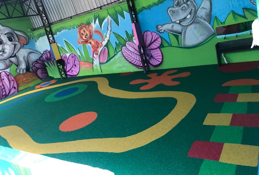 Vista aérea de playground escolar colorido com jogos pintados no piso monolítico